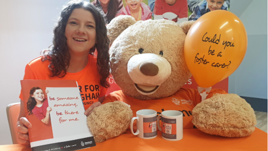 Foster carer Sian holding promotional materials for foster care fortnight