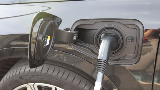 Close-up photograph of an electric vehicle charger plugged into a vehicle's socket