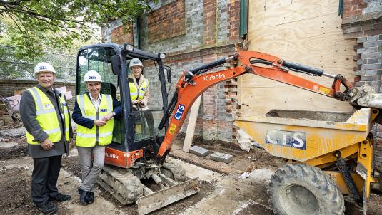 Cllr Sarah Kerr, Cllr Stephen Conway and Mr Weston from CTS stood next to a digger looking at the foundations for the new extension at the new Twyford Library