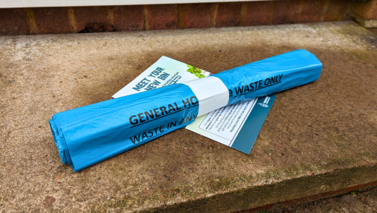 A roll of 20 blue bin bags and a leaflet on the doorstep