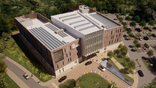 A computer generated aerial image of a new four storey building surrounded by woodland, with a small car park