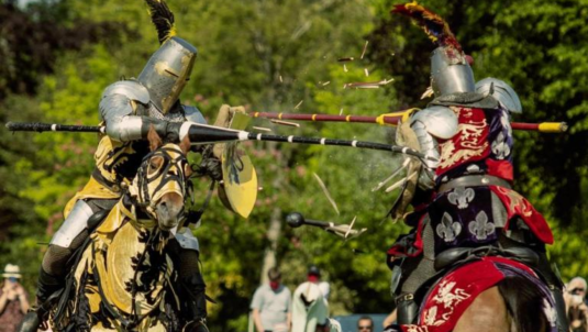 Two people on horses at medieval jousting event