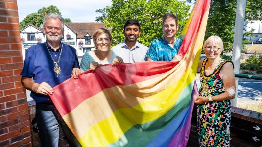 Wokingham Borough councillors raise the Pride rainbow flag at the council's Shute End offices