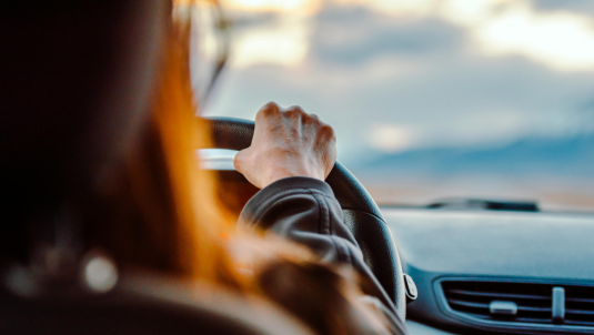 General view of someone anonymous behind the wheel of a car