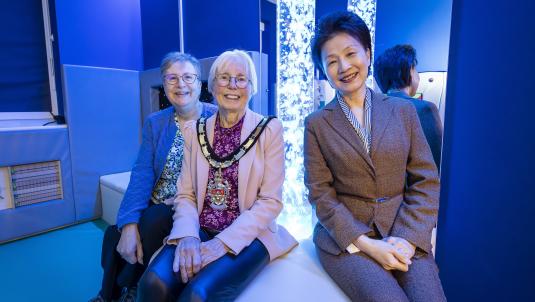 Borough Mayor Cllr Carol Jewell with Cllr Prue Bray and Headteacher Li-Juan Ellerton in the new sensory room. A light up, sensory lamp is behind them
