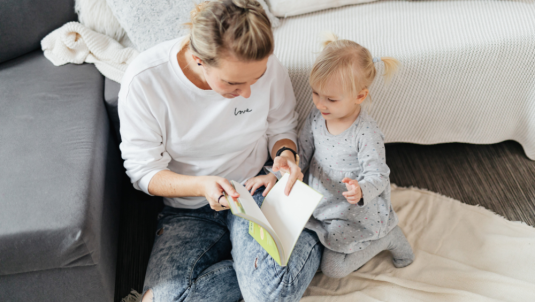 Mother and daughter sat reading a book