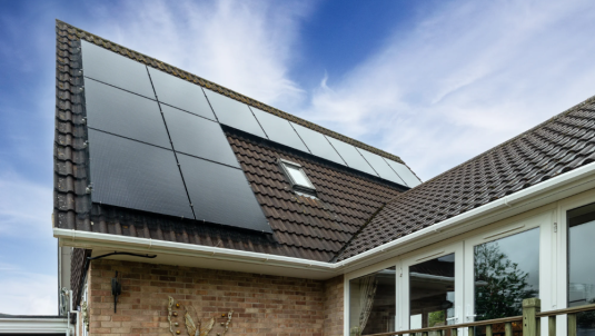 Solar panels installed on a modern home roof under a clear blue sky