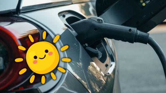 Photo of a charger plugged into an electric vehicle with a graphic of a smiling sun