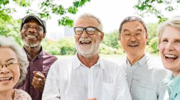 Group of male and female adults outside under a tree