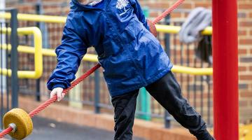 A pupil from Addington Early Years Centre playing outside on textured playground