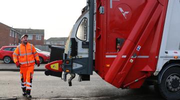 Biffa employee loading a wheeled bin onto a lorry 