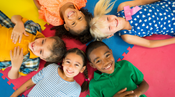 Children laying on a play mat, facing upwards