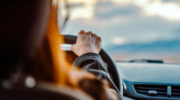 General view of someone anonymous behind the wheel of a car