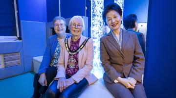 Borough Mayor Cllr Carol Jewell with Cllr Prue Bray and Headteacher Li-Juan Ellerton in the new sensory room. A light up, sensory lamp is behind them