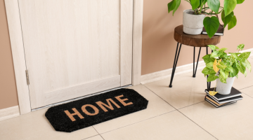 Front door with welcome mat saying 'home'