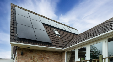Solar panels installed on a modern home roof under a clear blue sky