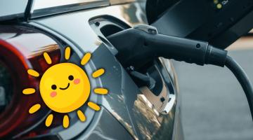 Photo of a charger plugged into an electric vehicle with a graphic of a smiling sun