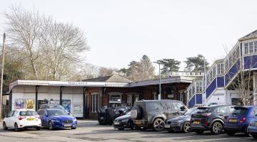The main entrance to Twyford station on a sunny day, with lots of cars parked in front