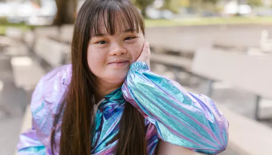 A teenager with downs syndrome smiling
