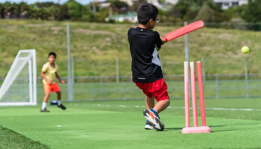 A boy playing cricket
