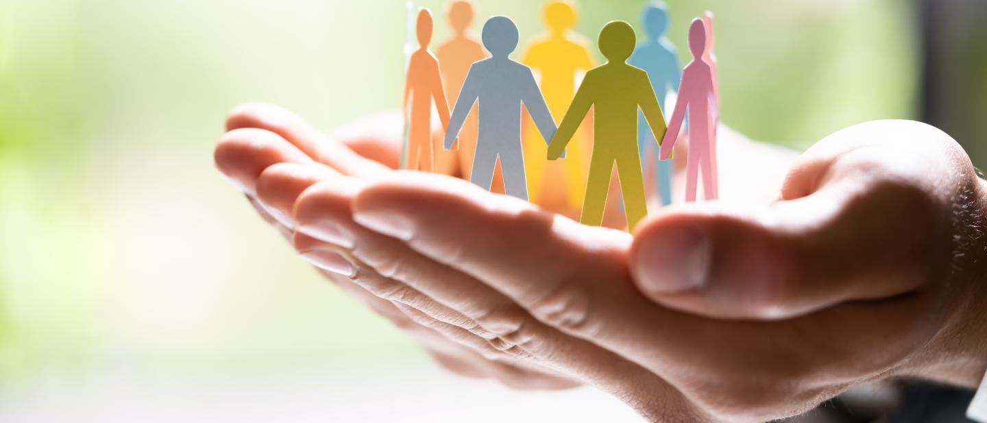 Hand reaching out with circle of paper people on it