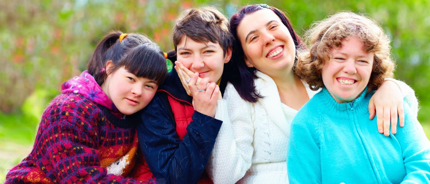 Four young female adults sitting together outside