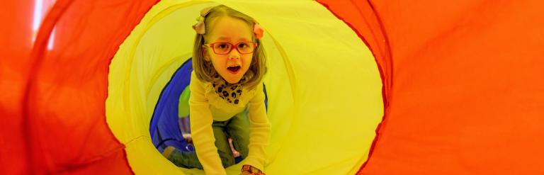 Girl in colourful fabric tunnel