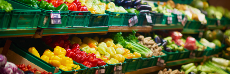 A long supermarket shelf with colourful fresh fruit and vegetables