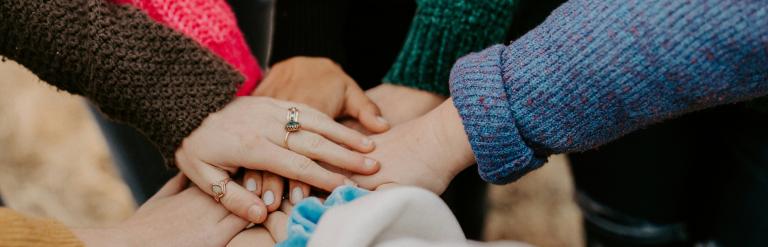 A group circle of hands in the middle to symbolise community
