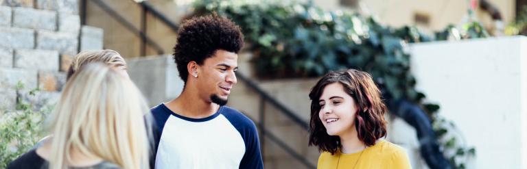 Three teenagers talking outside a college