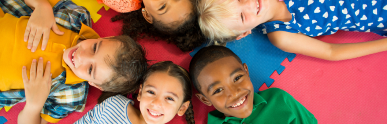 Children laying on a play mat, facing upwards